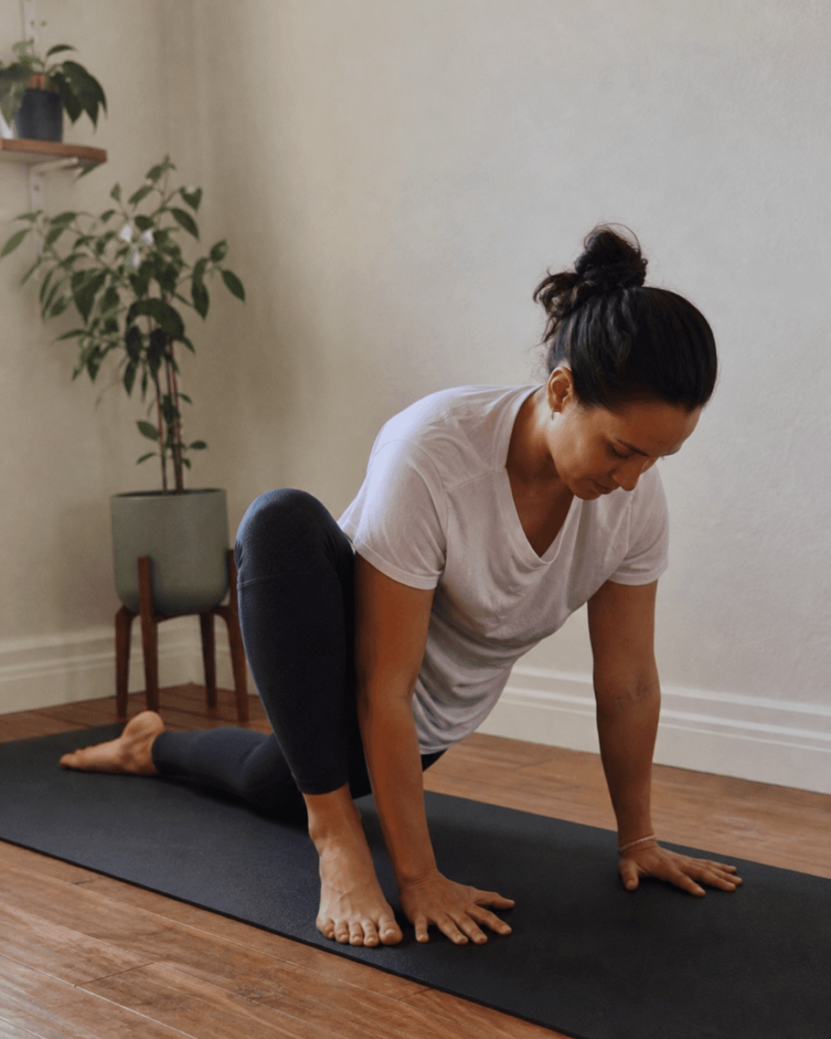 Principiante de fitness siguiendo un ejercicio guiado de flexibilidad sobre una colchoneta