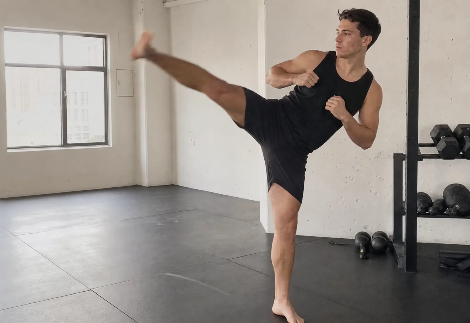 Athlete training a controlled high kick in a clean studio